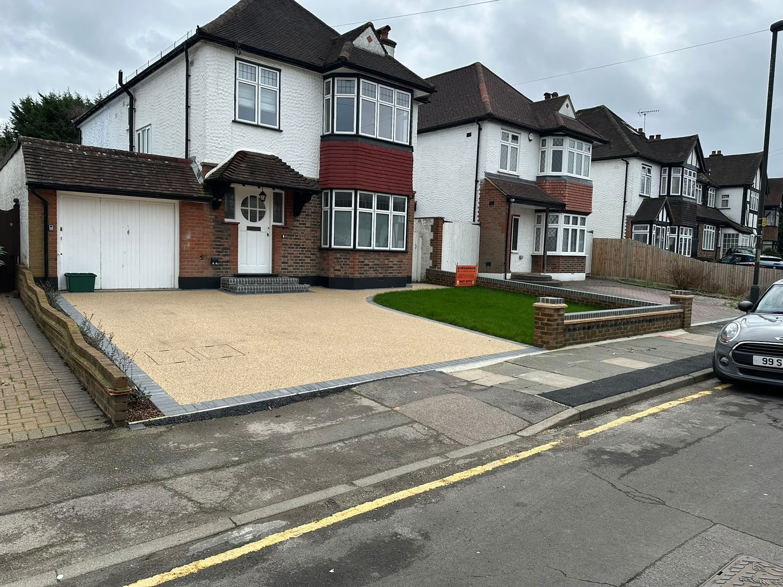 Resin bound driveway with block paving edging in front of a semi-detached house