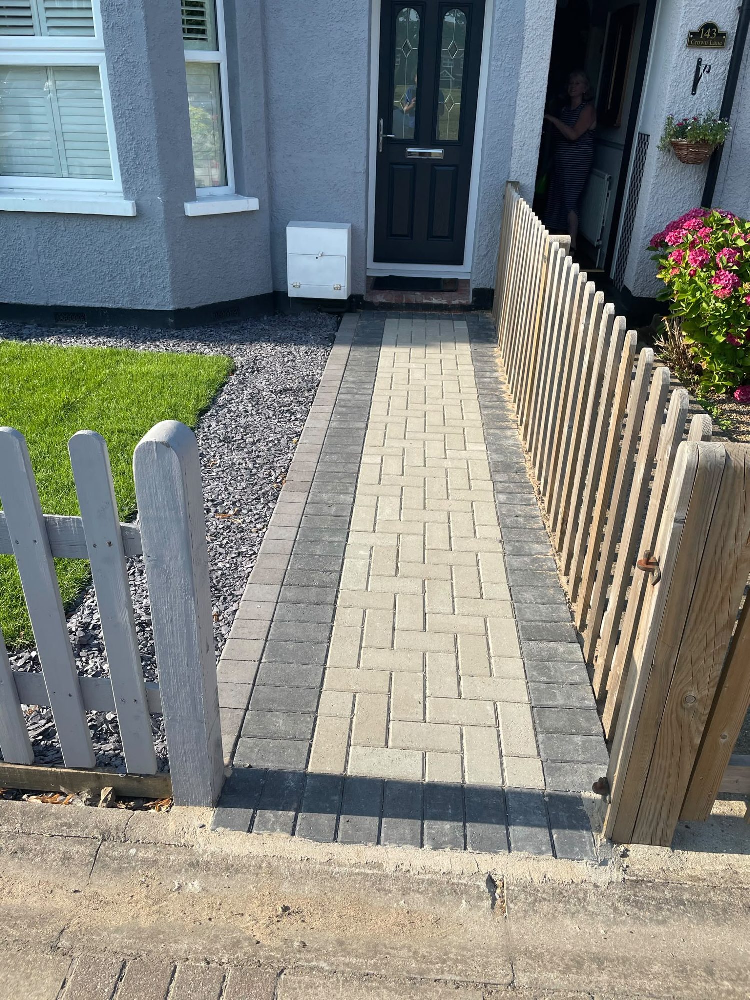 Buff block paved front garden path with charcoal edging and grey picket fence