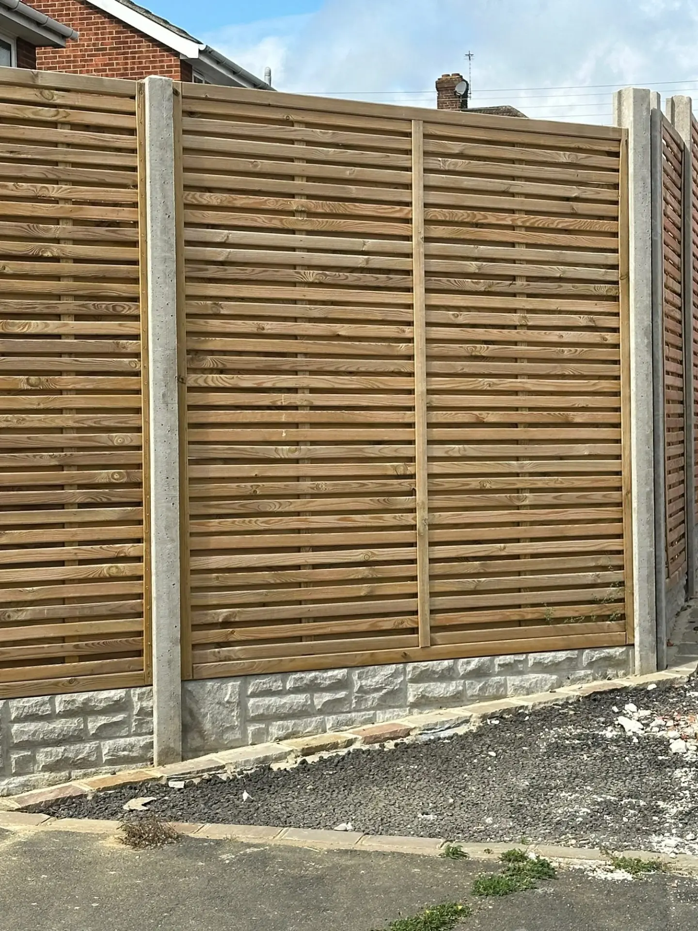 Horizontal timber fencing with concrete posts and textured concrete gravel boards