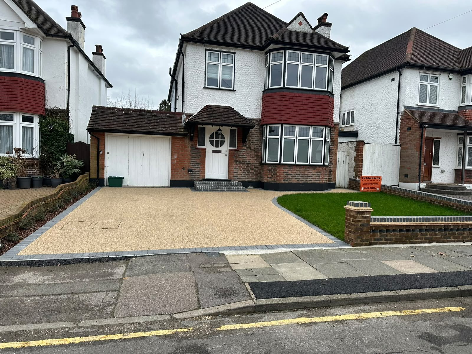 Resin bound driveway with block paving border in front of a 1930s semi-detached house